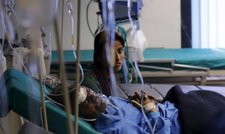 Un familiar se sienta junto a una víctima herida por el  terremoto, en un hospital de Katmandú, Nepal.- REUTERS / Adnan Abidi