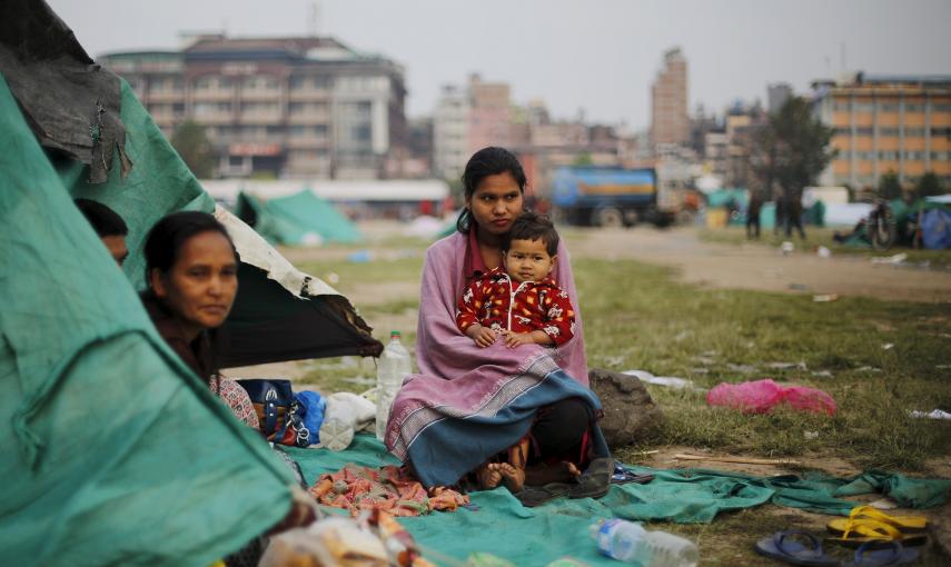 Una víctima del terremoto lleva en brazos a su hermana fuera de su refugio improvisado en las afueras de Katmandú, Nepal./ REUTERS/Adnan Abidi