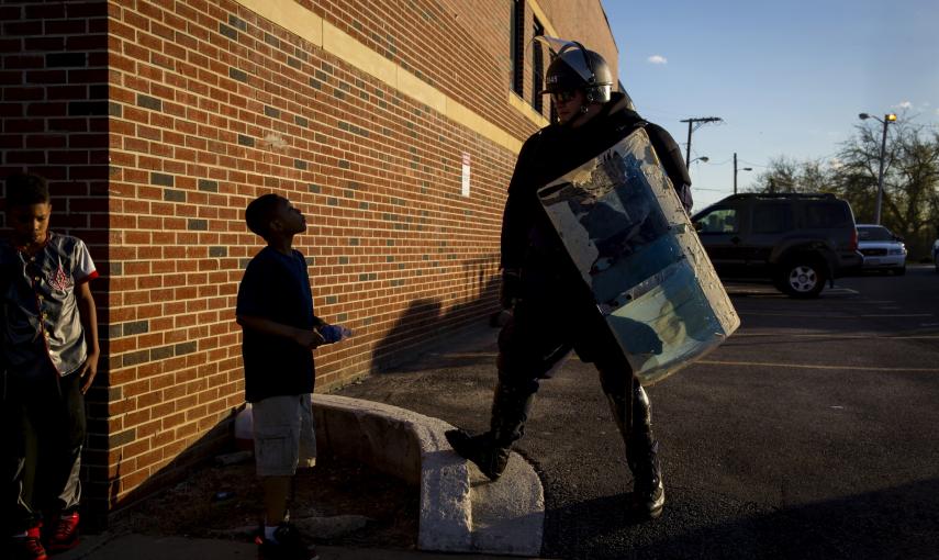A boy talks to a police officer near North Ave and Pennsylvania Ave in Baltimore. REUTERS/Eric Thayer