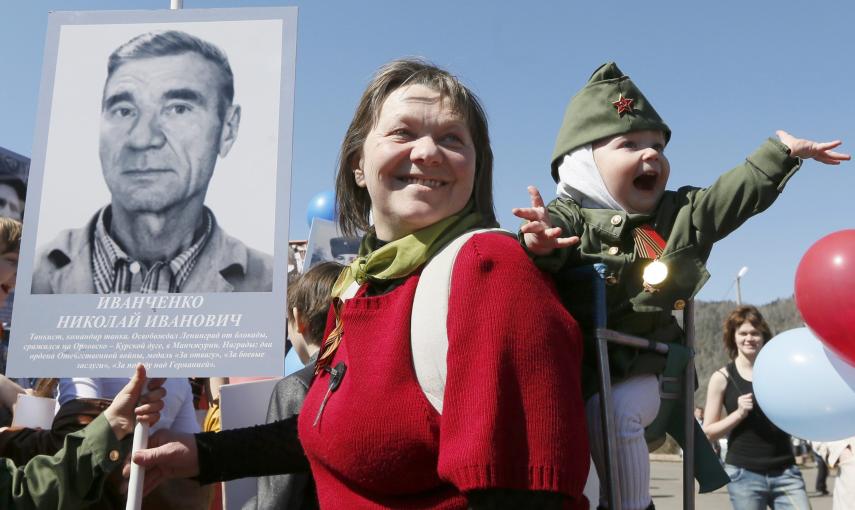 A woman with a child holds picture of World War Two soldier as she takes part in the Immortal Regiment march during the Victory Day celebrations in Divnogorsk. REUTERS/Ilya Naymushin