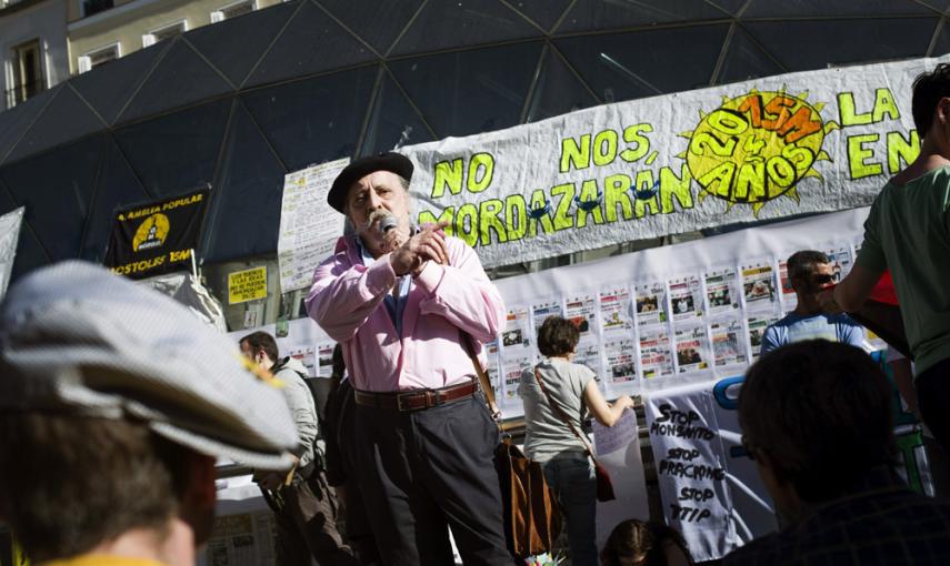 Un hombre habla ante una pancarta en la madrileña Puerta del Sol durante la celebración hoy del cuarto aniversario del movimiento 15M. EFE/Luca Piergiovanni