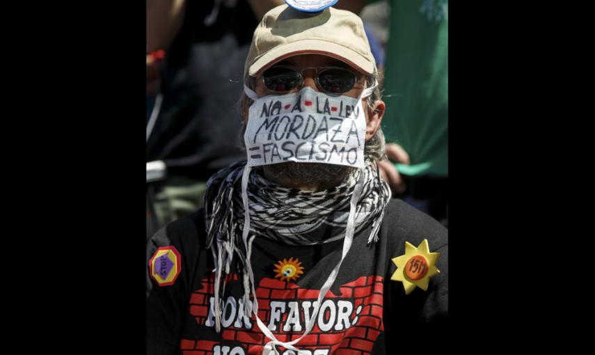 Una persona enmascarada protestando contra la ley mordaza, en la concentración en la madrileña Puerta del Sol para celebrar el cuarto aniversario del 15M.. REUTERS/Andrea Comas