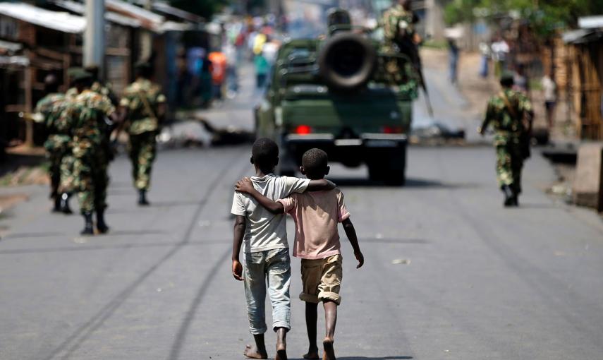 Dos niños caminan detrás de una patrulla de soldados en Bujumbrura (Burundi). Los militares intentaron un levantamiento militar hace dos días para poner fin a la ola de violencia desencadenada por la decisión de Nkurunziza de aspirar a un tercer mandato a