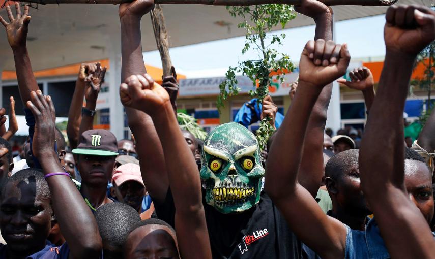Un manifestante oculta su identidad tras una máscara, durante una de las protestas en Bujumbura, contra la decisión del presidente de Burundi, Pierre Nkurunziza, de presentarse a una tercera reelección pese a la prohibición de la constitución.- GORAN TOMA