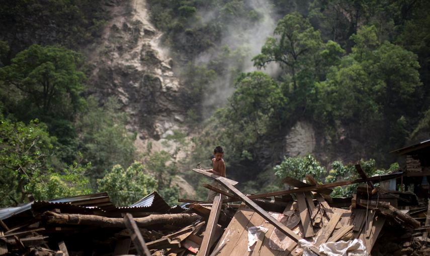 Un niño limpia aparta escombros entre las ruinas de su casa, tras el terremoto del martes en Singati Village, en Dolakha (Nepal).- ATHIT PERAWONGMETHA (REUTERS)