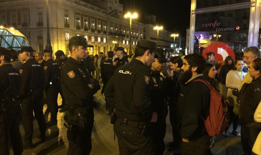 Agentes de la Policía Nacional identifican a uno de los asistentes a la concentración convocada por el movimiento 15-M para emitir un "grito silencioso" justo al comienzo de la jornada de reflexión, pese a la prohibición de la Junta Electoral Central. Fot