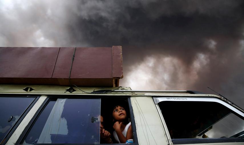 Una familia dentro de un coche mientras se preparan para dejar un área de la zona de peligro, mientras el volcán Monte Sinabung en Sumatra, Indonesia.- BEAWIHARTA (REUTERS)