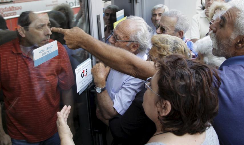 Pensionistas esperando en la puerta del Banco Nacional de Grecia para cobrar su pensión en Heraklion, en la isla de Creta, el día después de que se declarara el control de capitales, conocido como corralito. Los bancos sólo han abierto para que los jubila