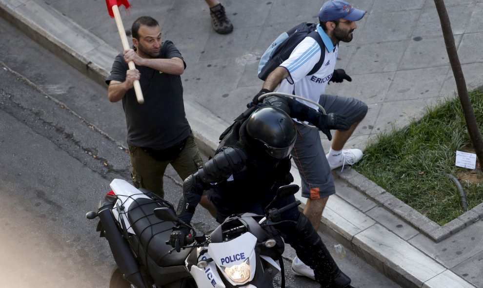 Un manifestante intenta golpear a un agente en las inmediaciones de la plaza Syntagma. - REUTERS