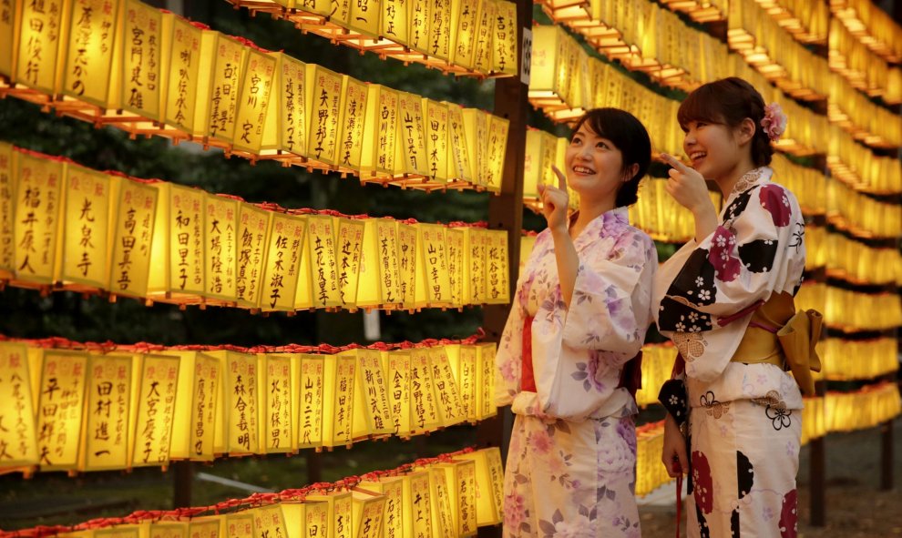 Dos mujeres ataviadas con trajes tradicionales partician en la festividad de verano de Mitama Matsuri en el templo de Yasukuni en Tokio (Japón). Cerca de 300.000 personas participan en esta festividad de tres días que se celebra para honrar a los muertos.