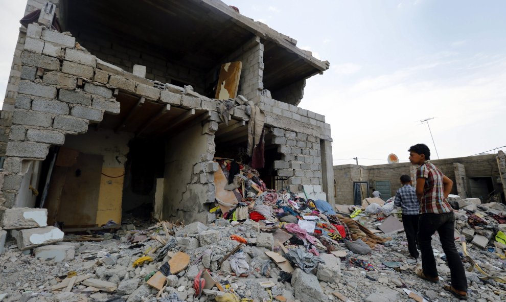 Un par de jóvenes observan los escombros de un edificio tras un bombardeo en Saná (Yemen). Al menos 21 personas, entre ellas niños y mujeres, murieron esta madrugada y otras 45 resultaron heridas en ataques aéreos de la coalición árabe en un barrio reside