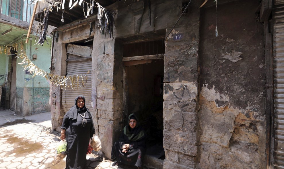 Dos mujeres conversan en su portal mientras el primer ministro egipcio, Ibrahim Mahlab (fuera de la imagen) visita el barrio en el que el pasado sábado se produjo un atentado, junto al consulado italiano, en El Cairo, Egipto. EFE/Khaled Elfiqi