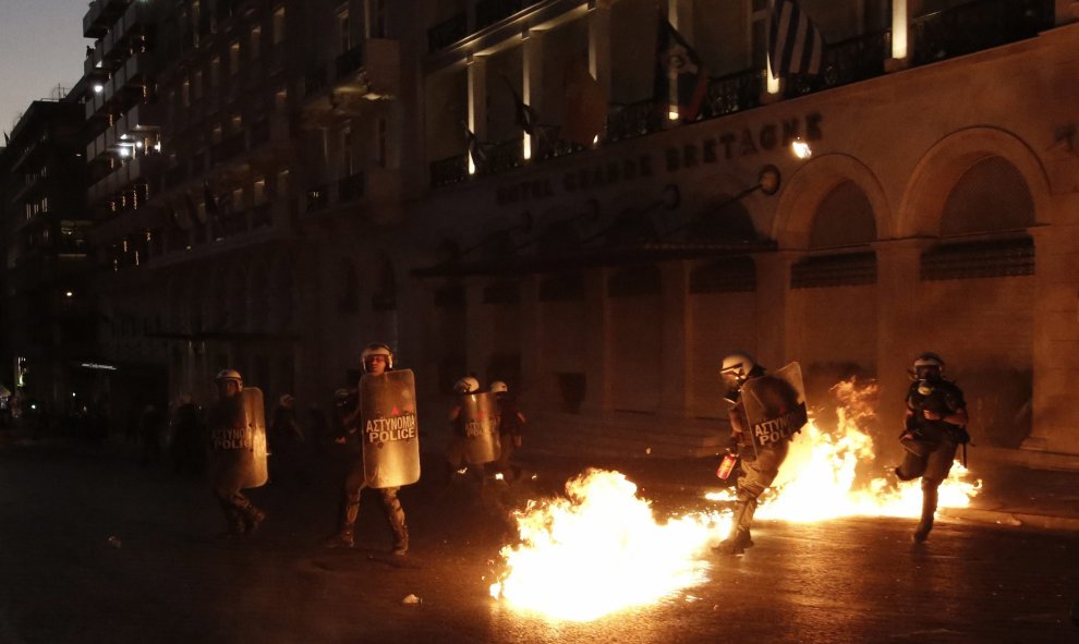 Los antidisturbios de la policía griga, acosados por el lanzamiento de cócteles molotov por parte de los manifestantes. EFE/ YANIS KOLESIDIS