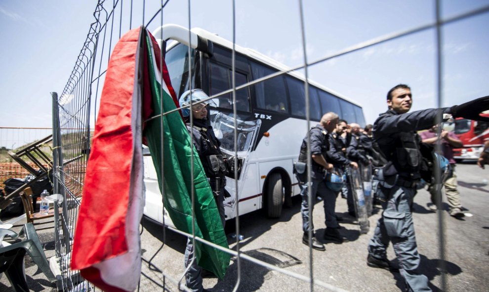 La policía italiana se prepara para despejar la carretera de manifestantes que protestan contra la llegada de un grupo de refugiados a un suburbio en el norte de Roma (Italia) hoy, 17 de julio de 2015.