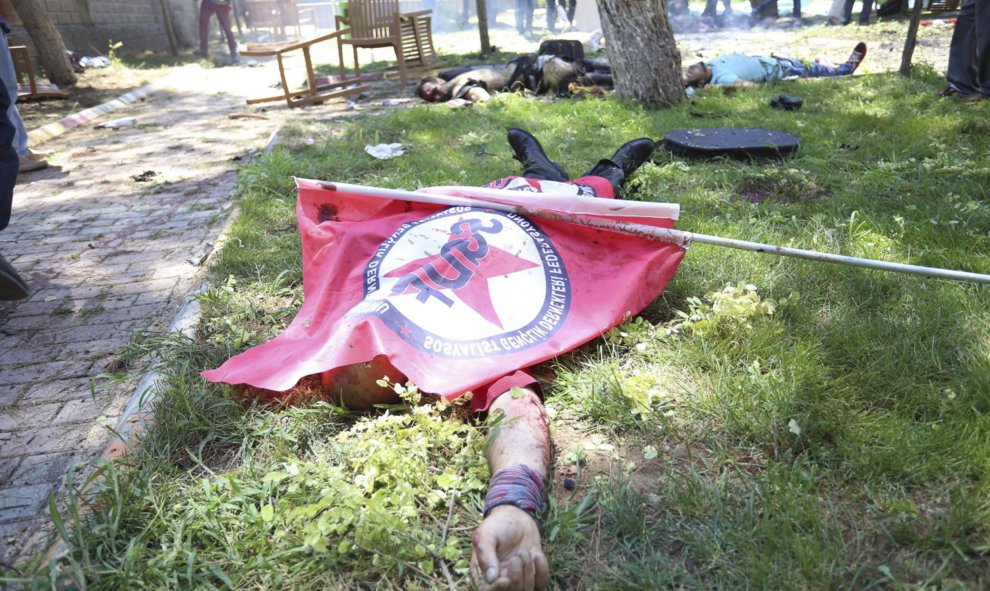 Un cuerpo permanece cubierto por una bandera tras la explosión de un artefacto en un centro cultural en Suruc, provincia de Sanliurfa (Turquía) hoy, 20 de julio de 2015. Al menos 25 personas han muerto y varias decenas han resultado heridas por la explosi