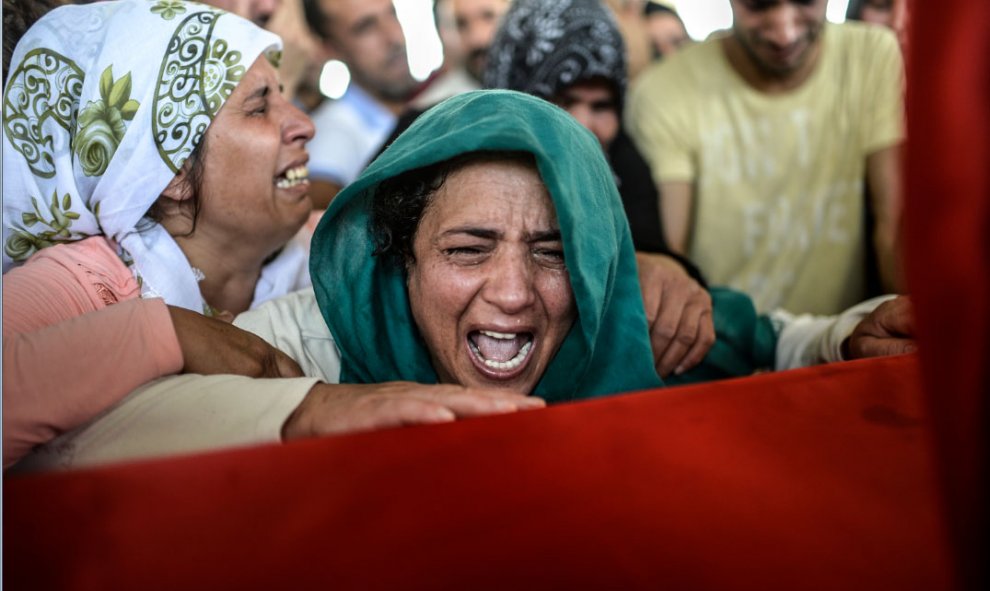 Amigos y familiares de las víctimas del atentado yihadista que causó al menos 30 muetros en Suruc ayer asisten al funeral de 16 de los fallecidos en Gaziantep (Turquía) hoy, 21 de julio de 2015./ AFP. BULENT KILIC