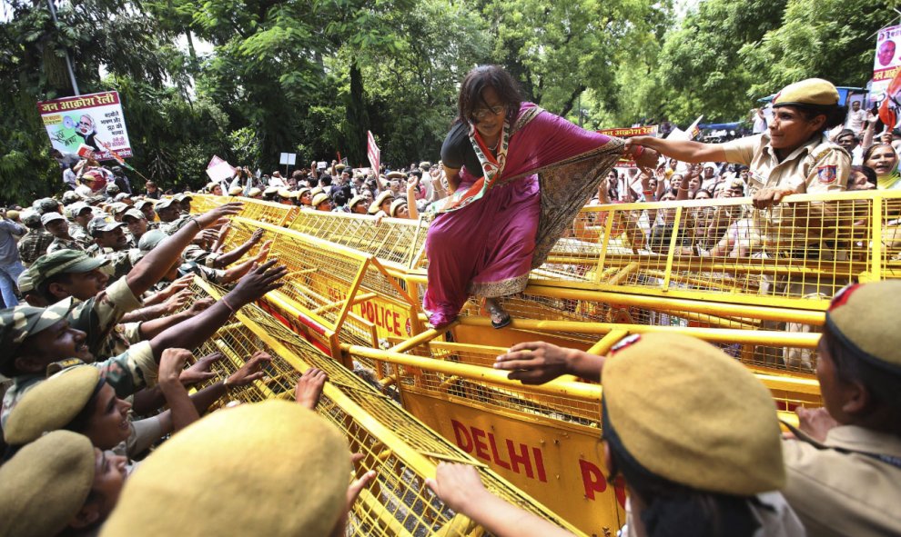 Una mujer de la sección femenina del Partido del Congreso intenta escalar una barricada durante una protesta contra el partido en el Gobierno, el Bhartiya Janta Party (BJP), en Nueva Delhi (India) hoy, 21 de julio de 2015. Las mujeres del partido protesta
