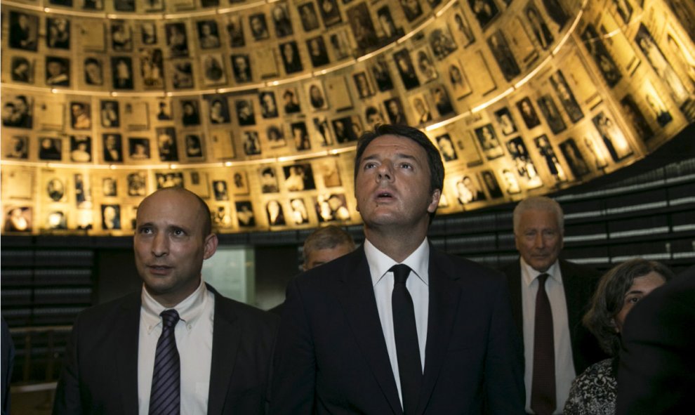 El primer ministro italiano Matteo Renzi (D) se encuentra con el ministro de Educación Naftali Bennett de Israel mientras mira fotos de judíos asesinados en el Holocausto, en una visita a la Sala de los Nombres en la Historia del Holocausto Museo de Yad V