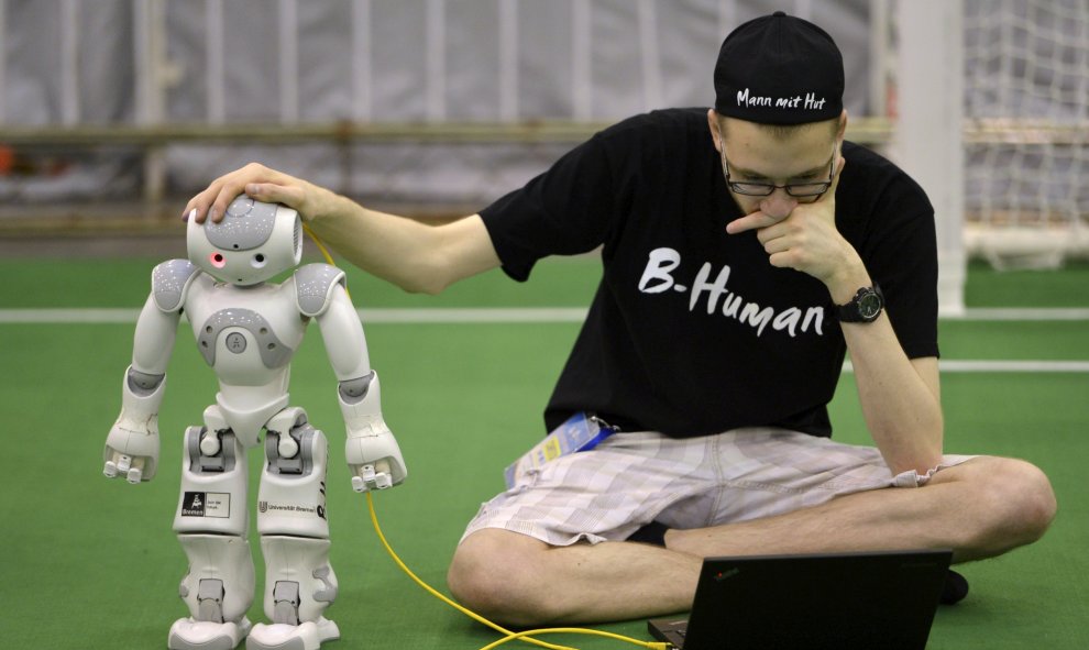 Un miembro de un equipo alemán ajusta un robot humanoide en las  finales de la Robocup 2015 en Hefei, provincia de Anhui, 22 de julio de 2015. La Robocup, es un concurso internacional de robótica que se celebra, este año, entre el 17 y 23 de Julio en Hefe