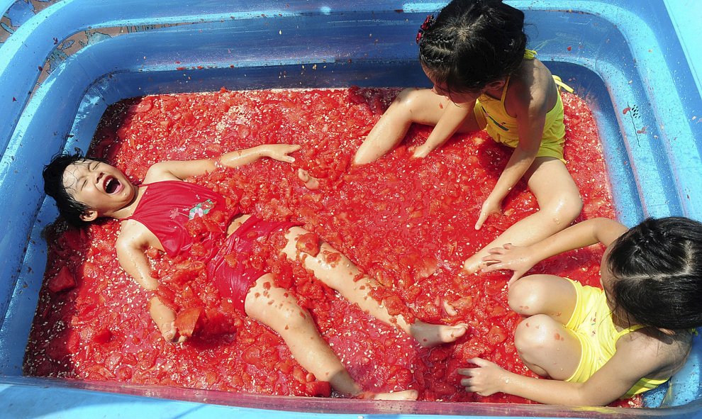 Unos niños juegan en una piscina llena de sandía para refrescarse en un parque de atracciones en Hangzhou, provincia de Zhejiang, China, 22 de julio de 2015. REUTERS / Stringer,