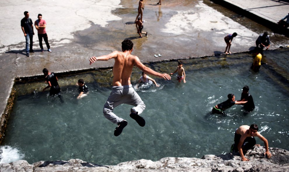 Jóvenes juegan en una piscina natural cerca de la fuente Cheshmed Ali, en el sur de Tehran, hoy, 22 de julio 2015. AFP PHOTO / BEHROUZ MEHRI