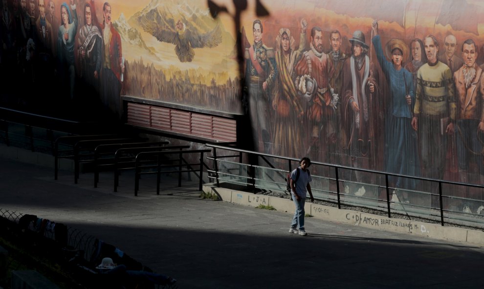 Un hombre camina al lado de un mural que representa personajes históricos de la época de la dominación española hasta los tiempos modernos en La Paz, Bolivia. REUTERS / David Mercado