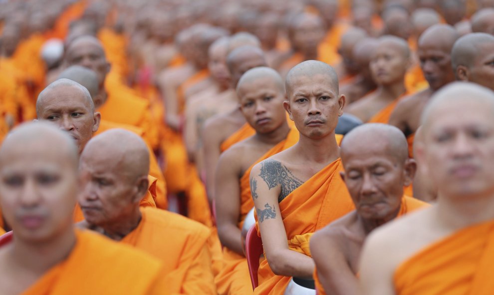 Varios monjes budistas participan en una ceremonia en la que los locales intentan hacer méritos a través de la entrega de flores, conocida como Tak Batdok Mai, al inicio de la cuaresma budista en las calles próximas al templo de Phra Phutthabat, en Sarabu