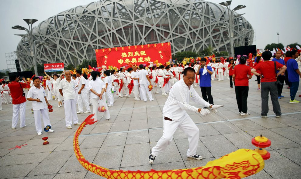 Gente celebrando que Beijing haya sido elegida como sede de los Juegos Olímpicos de Invierno 2022, que se celebrarán en el estadio olímpico Nido de Pájaro en Pekín, 31 de julio de 2015. REUTERS / Damir Sagolj