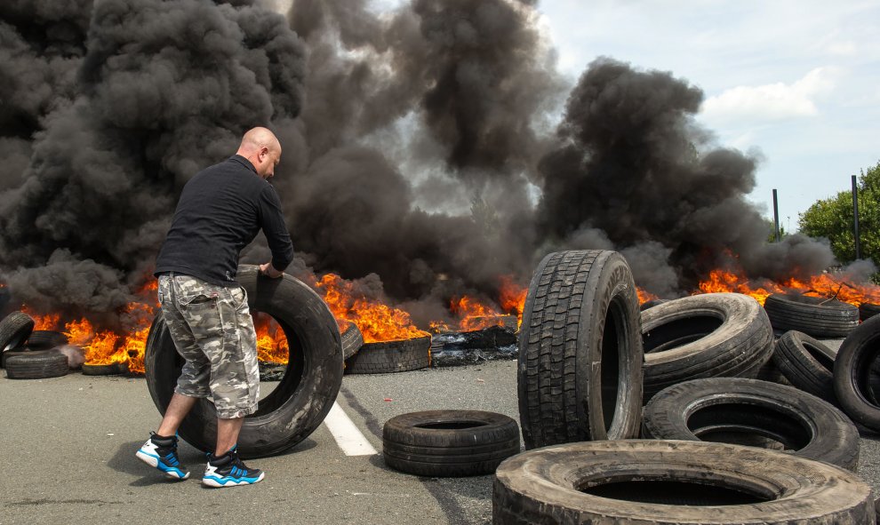 Los empleados de la empresa My Ferry Link bloquean el acceso al puerto con neumáticos en llamas durante la huelga el 31 de julio de 2015, en Calais, al norte de Francia, tras el fracaso de las negociaciones con el gobierno francés en relación con los reco