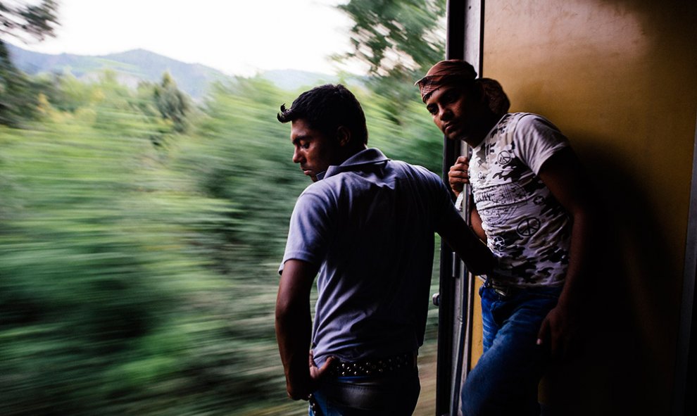 Inmigrantes miran por la puerta del vagón de tren en dirección norte desde Gevgelija a Tabanovce, en la frontera con Serbia.- DIMITAR DILKOFF (AFP)