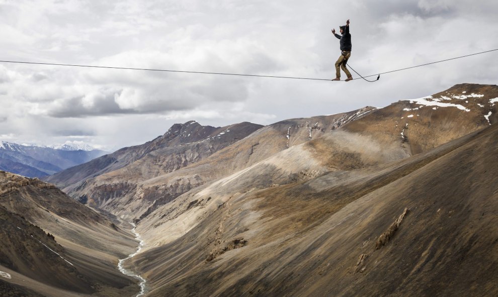 Fotografía facilitada hoy, 6 de agosto de 2015, que muestra al funambulista Bence Kerekes, miembro de un equipo húngaro de deportes de riesgo, mientras camina sobre un cable de 32 metros a una altura de 5.322 metros sobre la cadena montañosa de Ladakh en