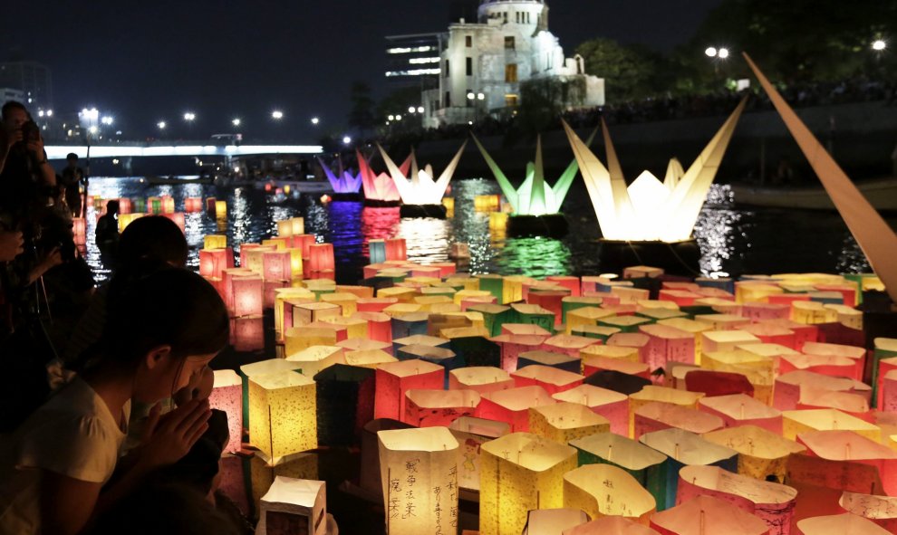 Varias personas iluminan linternas de papel junto al río Motoyasu en memoria de las víctimas de la bomba atómica en el Parque de la Paz de Hiroshima (Japón) hoy 6 de agosto de 2015. La bomba lanzada por un avión estadounidense sobre la ciudad nipona acabó