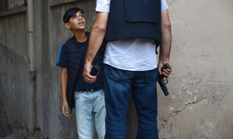 Un oficial de la Policía de Turquía hace preguntas a un niño kurdo después de un atentado contra agentes de la Policía turca en el centro de Diyarbakir, el 23 de julio de 2015. Un miembro del cuerpo fue abatido a tiros y hubo un segundo herido este vierne