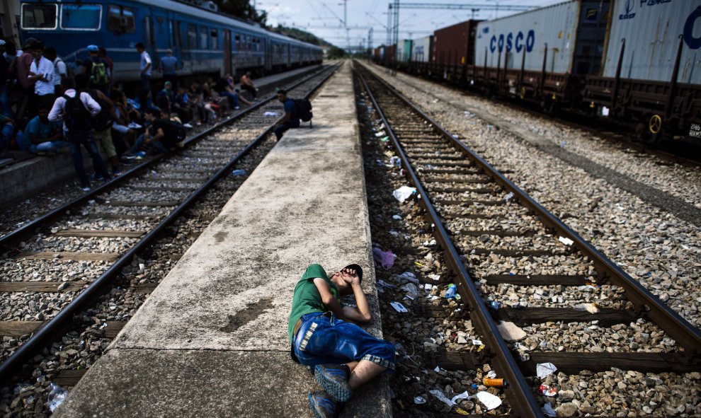 Un inmigrante descansa sobre una plataforma en la estación de tren en Gevgelija. Muchos inmigrantes tratan de cruzar Macedonia y Serbia para entrar en la Unión Europea a través de Hungría, un país terminará de construir su valla anti-inmigrante en su fron