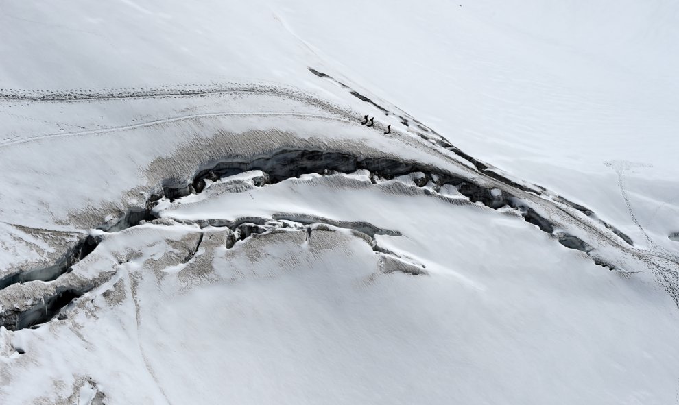 Varios escaladores caminan más cerca de las grietas en el glaciar des Géants (Glaciar de los Gigantes), junto al pico Aiguille du Midi en la montaña Mont-Blanc en Chamonix, al este de Francia. -AFP PHOTO / PHILIPPE DESMAZES