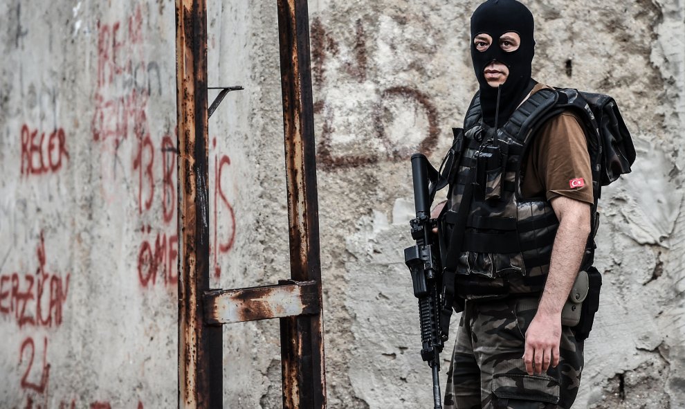 Un policía turco es fotografiado durante los enfrentamientos con los atacantes en 10 de agosto 2015 en el distrito Sultanbeyli en Estambul. OZAN KOSE / AFP