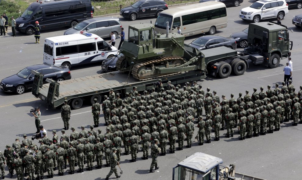 Policías paramilitares chinos permanecen en formación en los alrededores del lugar donde se han producido las explosiones. REUTERS