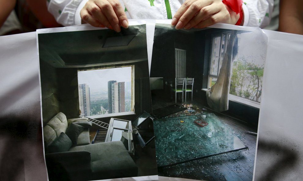 Una mujer muestra una imagen de cómo ha quedado su casa tras la explosión. La onda expansiva alcanzó a viviendas situadas a varios kilómetros a la redonda. REUTERS