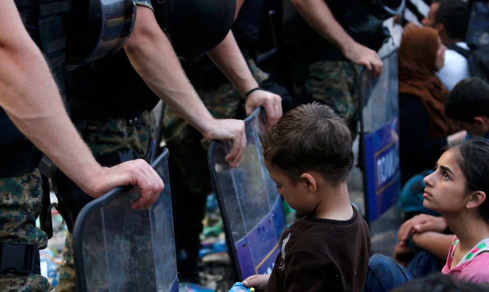 Una niña espera en la parte griega de la frontera con Macedonia el permiso para cruzar, cerca de la ciudad sureña de Gevgelija- EFE / EPA / GEORGI LICOVSKI.- REUTERS/Yannis Behrakis