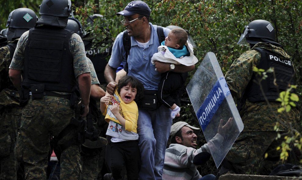 Dos niños sirios lloran entre las cargas de la policía contra los refugiados en la frontera entre Grecia y Macedonia.- REUTERS/Ognen Teofilovski