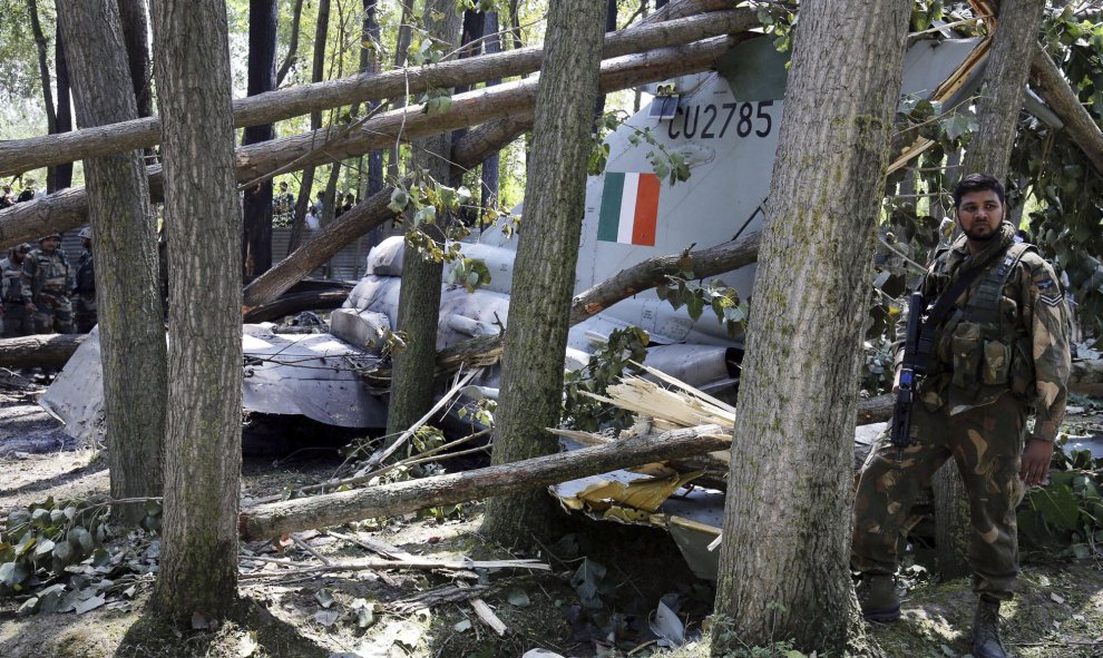 Un soldado indio al lado de los restos de un avión de las Fuerzas Aéreas en Soibugh en Budgam a unos 15 km de Srinagar (India), 24 de agosto de 2015. No se han producido daños personales en el accidente ya que el piloto consiguió eyectarse a tiempo antes