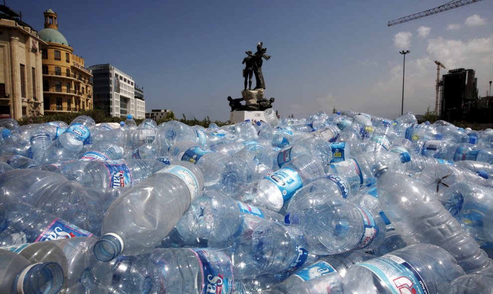 Reúnen botellas de agua para ser recicladas cerca de una estatua en la Plaza de los Mártires en Beirut, Líbano 25 de agosto de 2015. REUTERS / Jamal Saidi