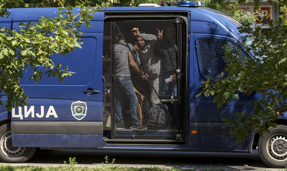 Refugiados sirios son transportados dentro de un vehículo de la policía serbia en el pueblo de Horgos cerca de la frontera de Serbia con Hungría.- REUTERS / Marko Djurica