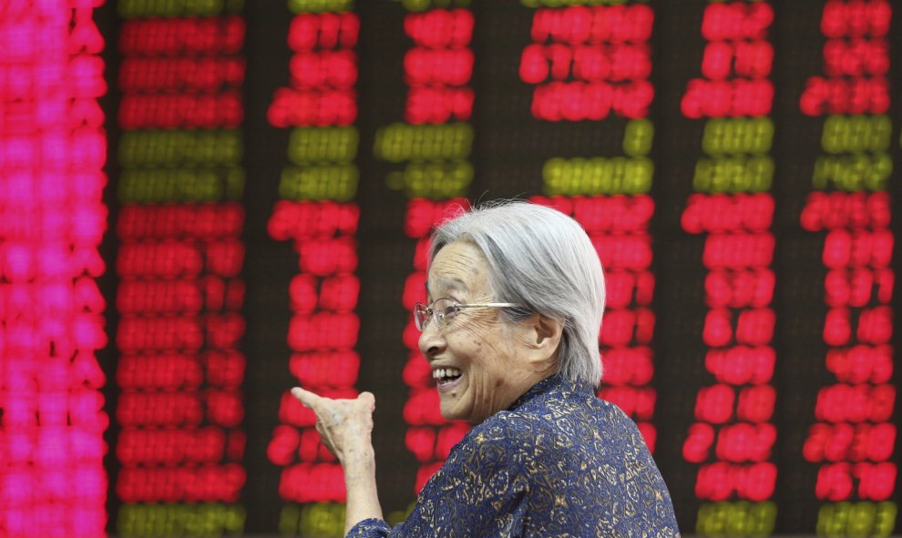 Una mujer sonríe al ver la información bursátil en la paNtalla de una oficina de corretaje en Pekín (China) hoy, 27 de agosto de 2015. EFE/Wu Hong