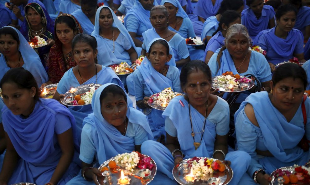 Mujeres hindúes sostienen platos decorados con elementos religiosos esperan para empatar " Rakhi " a los santos hindúes durante una función en Nueva Delhi. REUTERS