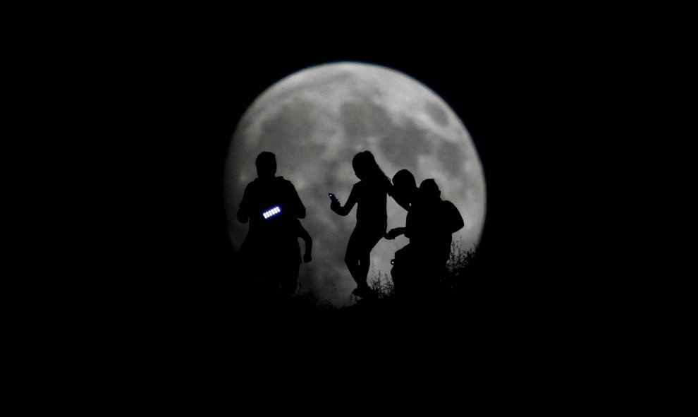 La silueta de un grupo de excursionistas se ve dibujada en la luna en Tijuana. REUTERS