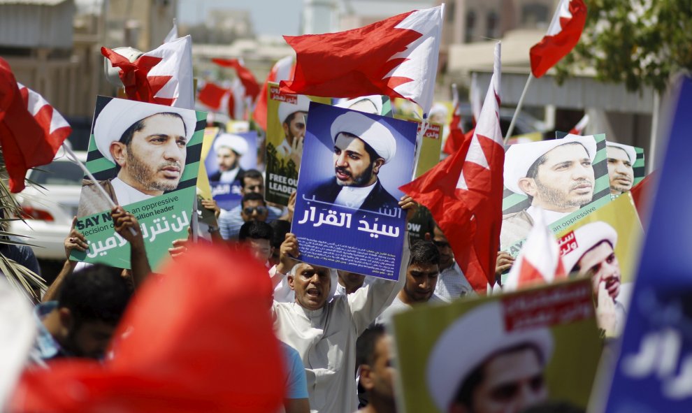 Los manifestantes sostienen banderas de Bahrein y pancartas con imágenes de Salman durante una manifestación después de las oraciones del viernes en la aldea de Diraz. REUTERS