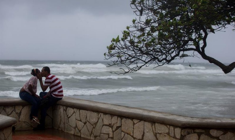Jóvenes son vistos a la llegada de la tormenta tropical Erika hoy, viernes 28 de agosto de 2015, en Santo Domingo (República Dominicana). El centro de la tormenta tropical Erika se aproxima hoy al país mientras deja fuertes lluvias en Puerto Rico y las Is