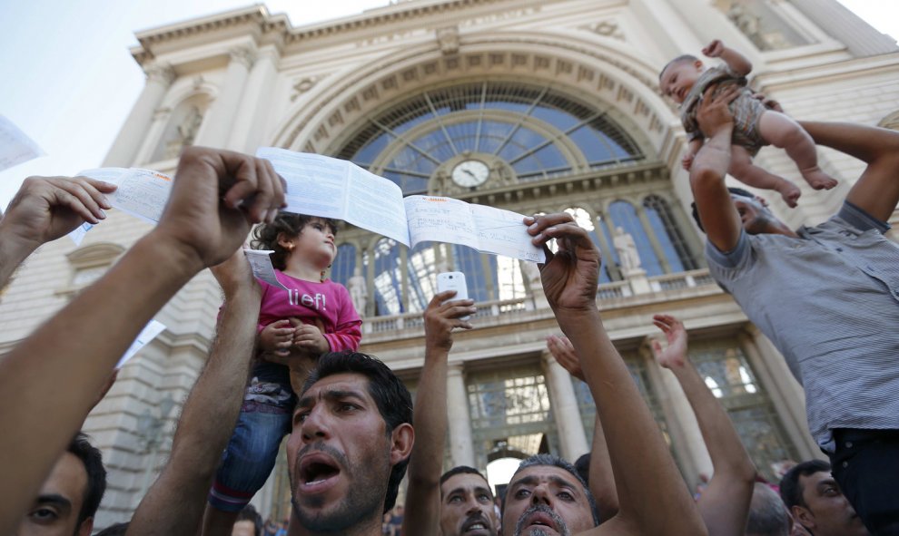 Cientos de inmigrantes protestan y muestran sus billetes a las puertas de la estación de Keleti, en Budapest. REUTERS