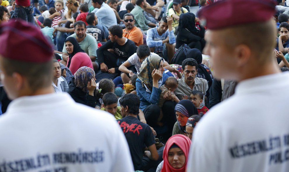 Cientos de inmigrantes custodiados por la policía esperan a las afueras de la estación de Keleti, en Budapest. REUTERS